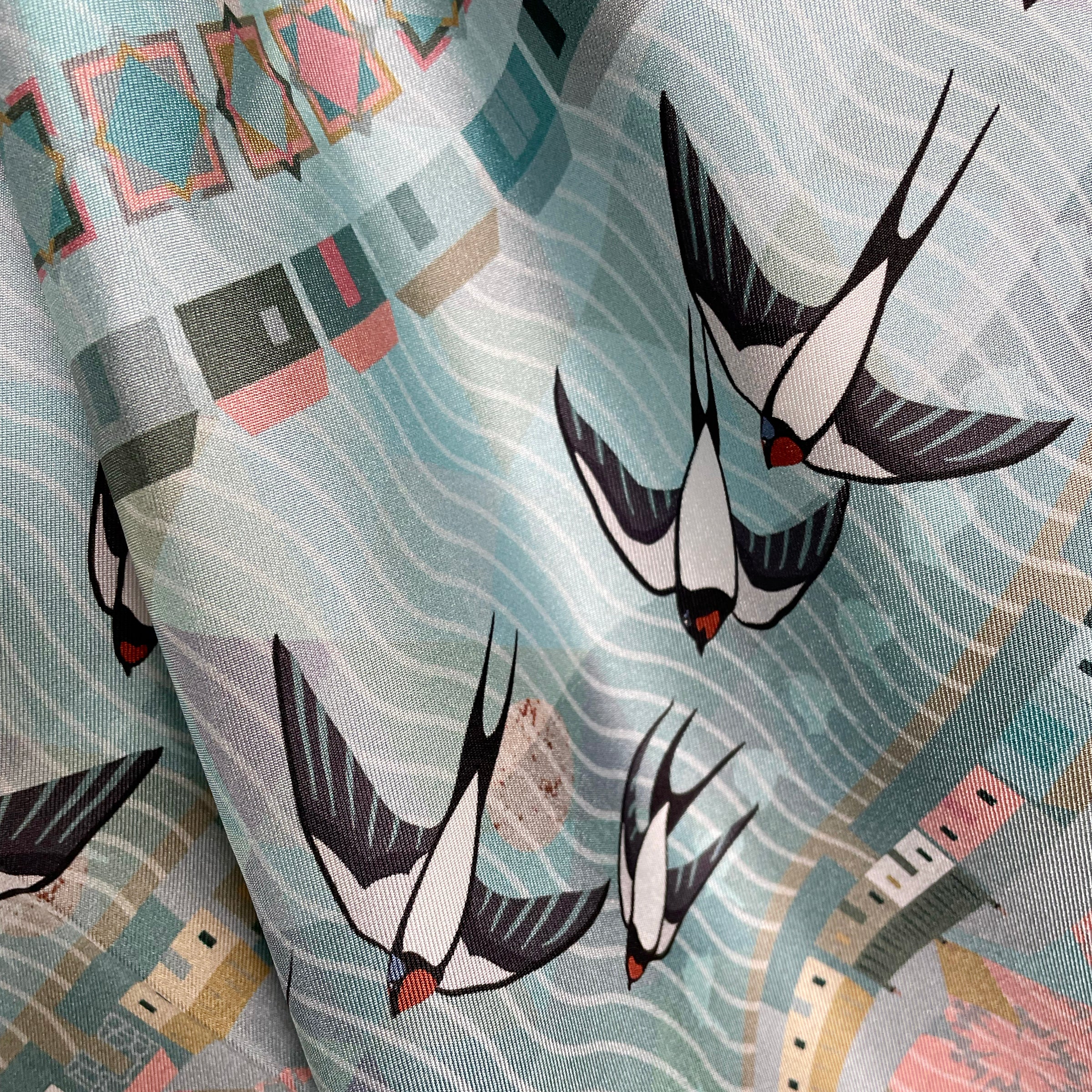 A detail of swallows printed on silk twill